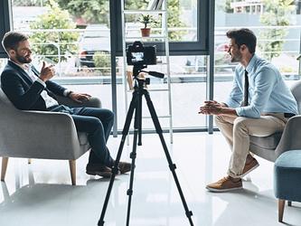 Two business men chatting while being capured on video, representing the idea of conducting qualitative research